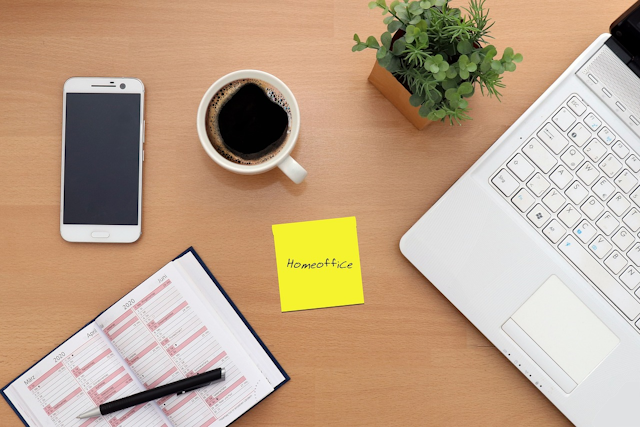 Schreibtisch von oben mit Smartphone, Kaffee, Kalender und Laptop